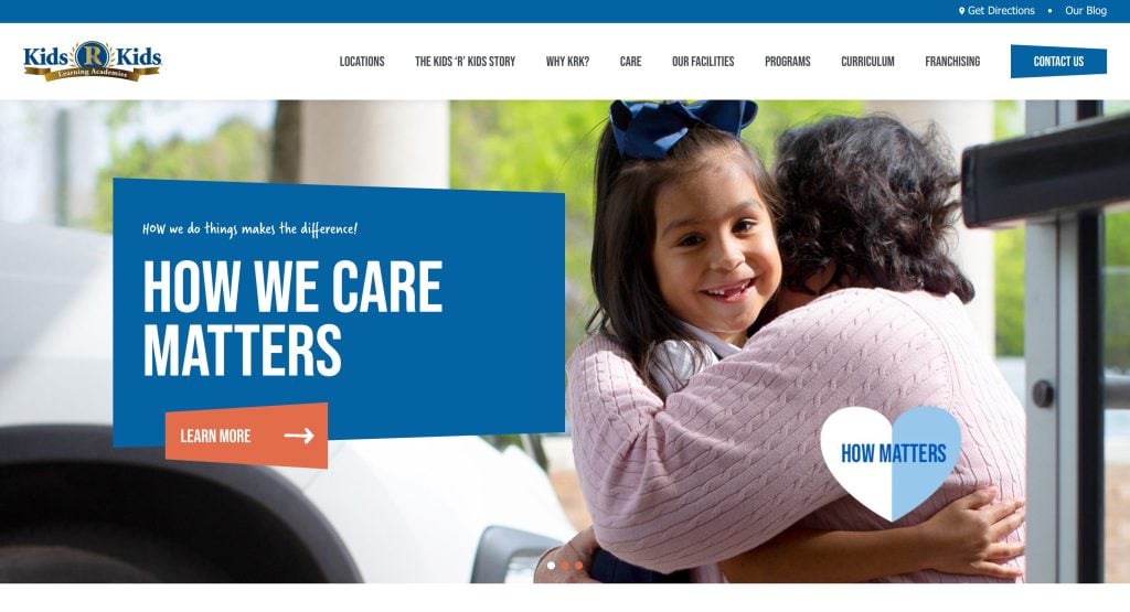A young girl smiles while being hugged by a woman outside. The website header reads Kids R Kids, with a navigation menu and large blue banner stating How We Care Matters—a great example of daycare website design—next to a Learn More button.