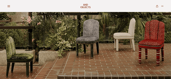 Four patterned chairs in varying colors are displayed outdoors on brick steps, surrounded by lush plants and greenery—ideal for inspiration when browsing furniture websites.