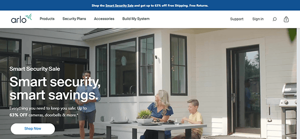 A family sits outside a white house with a security camera in view. Check out home security websites for a sale offering up to 63% off cameras, doorbells, and more to keep your loved ones safe and secure.