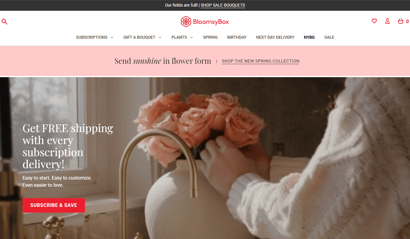A person arranges peach roses in a vase on a kitchen counter, seeking inspiration from the best florist websites. A banner offers free shipping with subscription delivery at BloomsysBox.