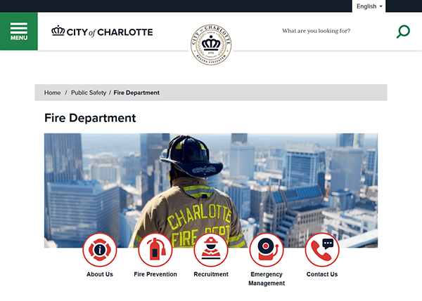 Firefighter overlooking cityscape from a rooftop, with "Fire Department" proudly displayed in the header. Icons for services like emergency management and contact info enhance one of the best fire department websites. The City of Charlotte logo stands prominently.
