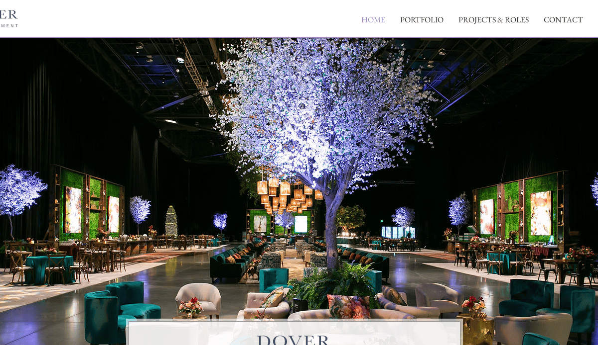A large, elegant event space decorated with illuminated artificial trees, lush greenery, modern lounge seating, and hanging lanterns—ideal for event planners seeking a luxurious and inviting atmosphere.