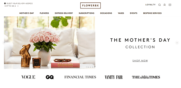 A website banner showcasing "The Mother's Day Collection" with pink roses in a vase, a gold hand sculpture, and a book on a white surface—a testament to the best florist websites. Logos of Vogue, GQ, and Vanity Fair add an elegant touch below.
