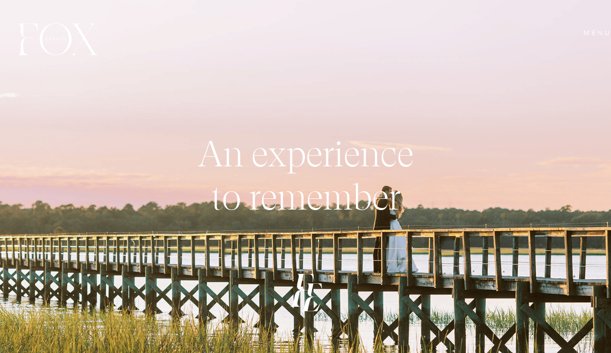 A couple embraces on a long wooden pier at sunset, romantic skies overhead. White text reads, “An experience to remember.” Perfect inspiration for Events Site vibes and the Best Event Planners to create unforgettable moments.