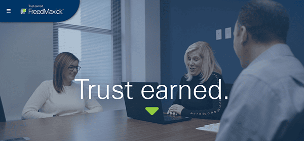 Three people in an office meeting room, with one using a laptop exploring CPA Websites. The text "Trust earned." is displayed over the image, emphasizing reliability and professionalism.