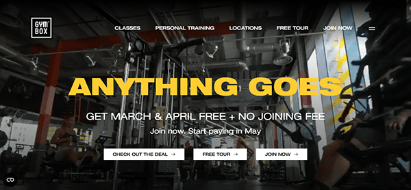 Step into a gym interior showcasing top-notch exercise equipment, where the bold yellow text declares "ANYTHING GOES." This is one of the best gym websites offering an irresistible deal: "Get March & April Free + No Joining Fee. Join now. Start paying in May." Don't miss out—join now!.