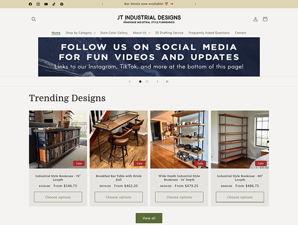 Screenshot of a webpage for JT Industrial Designs highlights trending designs like bookcases and bar tables, with a banner promoting their social media for videos and updates. Visit one of the best furniture websites to explore stunning pieces and discover furniture refinishing tips.