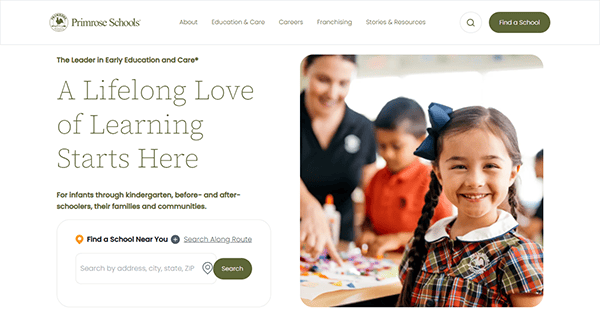 A young girl beams in a classroom setting, surrounded by an adult and kids. This scene captures the essence of early education, promoting lifelong learning. Discover nearby schools and explore daycare websites to find the best fit for your child's educational journey.