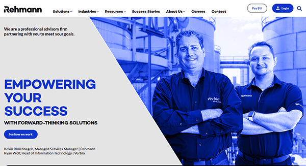 Two men smiling with arms crossed, standing outdoors in front of industrial tanks. Text on the left reads, "Empowering Your Success With Forward-Thinking Solutions," just like the best CPA websites that rank at the top for innovation and reliability.