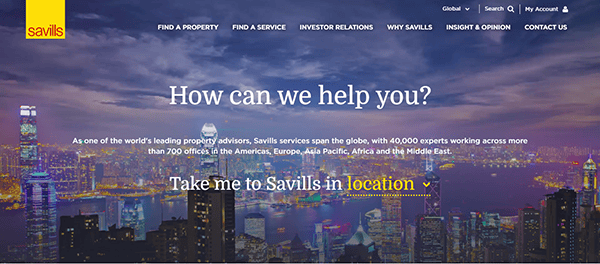 City skyline at dusk with illuminated buildings, text overlay reads, "How can we help you?" and "Take me to Savills in location," highlighted in yellow and white. Discover the best commercial real estate websites for your needs.