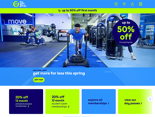 A man works out energetically in the gym, surrounded by vibrant promo banners offering up to 50% off membership and other discounts. Discover more deals on the best gym websites for all fitness enthusiasts.