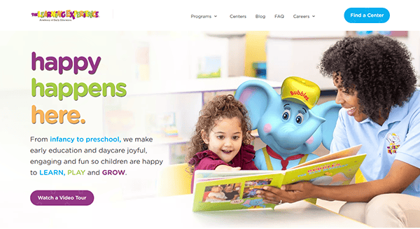 At The Learning Experience center, a child and teacher enjoy reading a book alongside an elephant mascot, creating memorable moments at one of the best daycare facilities.