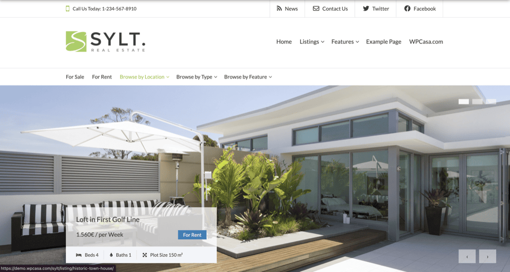 Modern white house with large windows and outdoor seating area under a parasol. Text overlay indicates it's a rental at 1,500€ per week. Website navigation bar visible at the top.