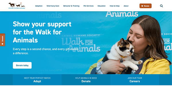 A woman holds a cat and kisses its head in front of a blue background with text promoting the Animal Humane Society’s Walk for Animals event, celebrating pet adoption and raising awareness for the best pet adoption opportunities.