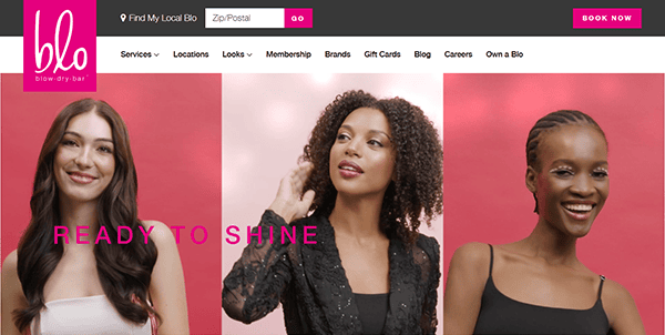 Three women with styled hair pose in front of pink backgrounds on the Blo Blow Dry Bar homepage, showcasing bold "READY TO SHINE" text—an inspiration for standout salon website design.