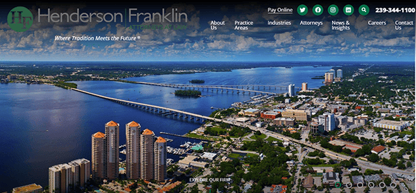 Aerial view of a city by the water with bridges, tall buildings, and the Henderson Franklin law firm website header—featured among the Best Personal Injury Websites—displaying navigation links and contact information.