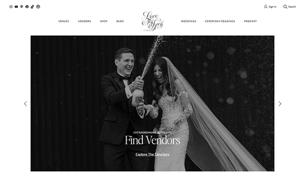 A bride and groom laugh while popping a bottle of champagne, with "Find Vendors" and site navigation options displayed on one of the best wedding websites for seamless wedding planning.