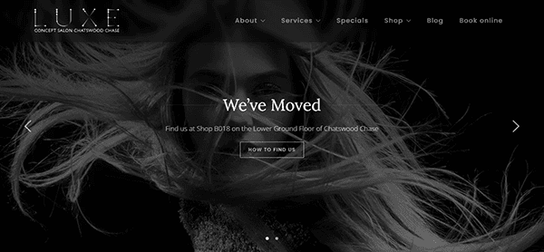 Monochrome image showing a woman with flowing hair and text announcing that LUXE Concept Salon has moved to Shop B018, Lower Ground Floor, Chatswood Chase—visit one of the best salon websites for more details.