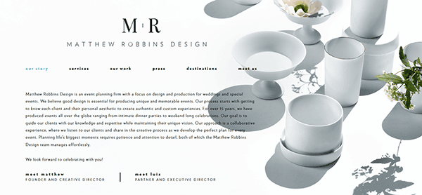 Homepage of Matthew Robbins Design featuring minimalist white tableware, a white flower arrangement, and info about their wedding planning services—an inspiring example for the best wedding planner websites, with navigation links at the top.