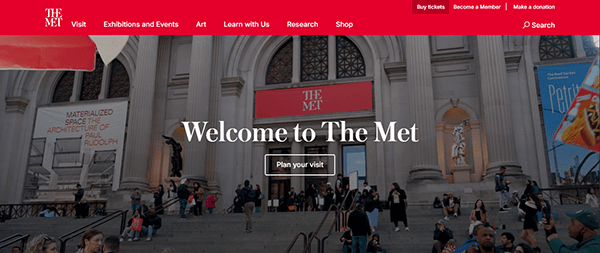 People gather on the steps outside The Met museum in New York City, with banners and columns framing the entrance. A "Welcome to The Met" message is displayed, marking it as one of the top museum websites for planning your visit.