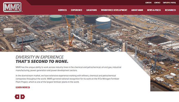 An aerial view of an industrial construction site, where cranes and large storage tanks meet a clear sky, showcases the precision and expertise similar to those found on the best industrial electrician websites.