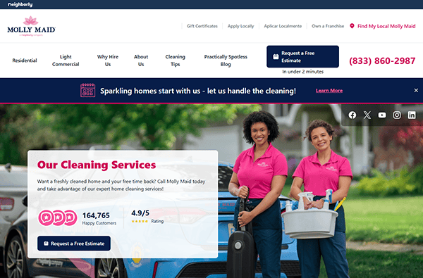 Two women in pink shirts stand smiling with cleaning supplies in front of a car, representing one of the best local service companies. The Molly Maid website offers options to request a free estimate and includes a contact number for easy access to top-notch cleaning services.