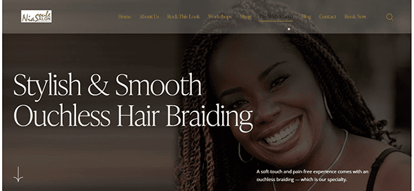 A smiling woman with braided hair is featured on one of the best salon websites, offering stylish and smooth ouchless hair braiding services. The sleek salon website design includes a visible menu at the top.