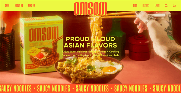 A bowl of noodles with a fried egg and sauce sits next to an Omsom Saucy Noodles box; a tattooed arm holds chopsticks above the bowl. Bold text promotes Asian flavors, inspiring best small business websites with vibrant food imagery.