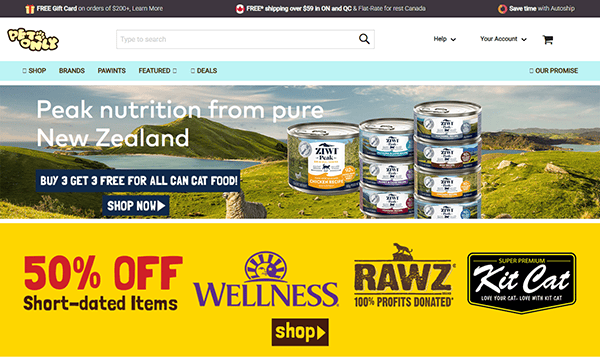 Homepage of one of the best pet shop websites, featuring a banner for New Zealand cat food, a "50% off short-dated items" deal, and logos for Wellness, RAWZ, and Kit Cat brands.