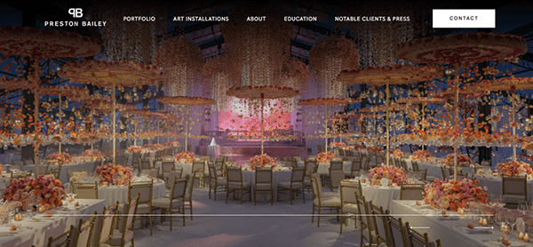 Elegant event space with floral centerpieces and hanging arrangements, set for a formal dinner under soft ambient lighting—inspiration often found on the best wedding planner websites.