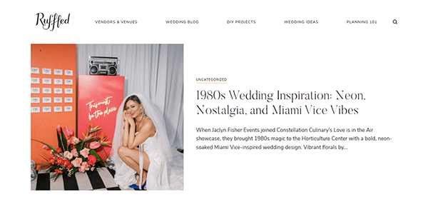 A bride in a white veil sits on the floor beside a neon pink "Forever and Ever, Babe" sign and vibrant orange florals—perfect inspiration for those seeking unique wedding website ideas.