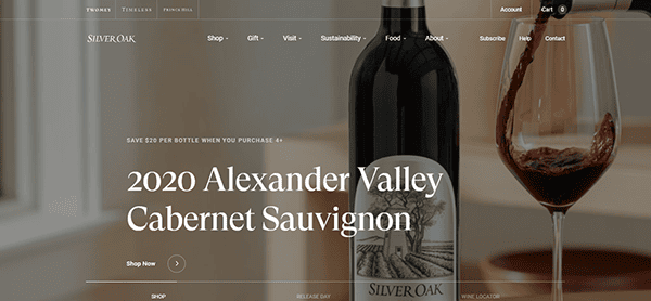 A bottle of Silver Oak 2020 Alexander Valley Cabernet Sauvignon is displayed next to a glass being poured with red wine on a minimalist background, evoking the elegance often featured on the best winery websites.