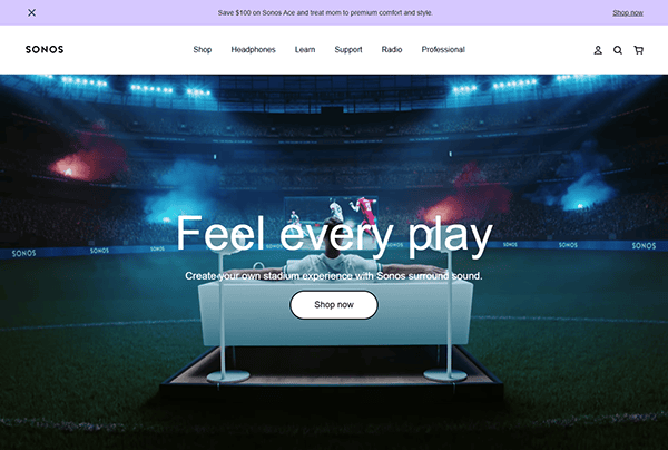 A stadium scene with two soccer players in action is displayed behind a platform featuring Sonos speakers—perfect for any smart home—with the text “Feel every play” and a “Shop now” button in the foreground.