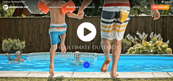An adult and child, both in swimsuits, hold hands and jump into a backyard swimming pool on a sunny day, with website navigation menus from one of the best pool builder websites visible at the top.