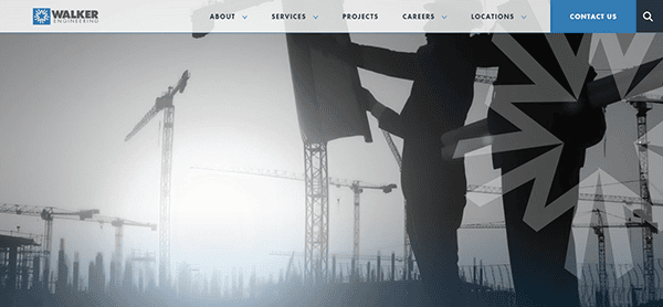 Silhouettes of two people reviewing plans, framed by construction cranes and a city skyline, suggest the expertise found on the best industrial electrician websites.