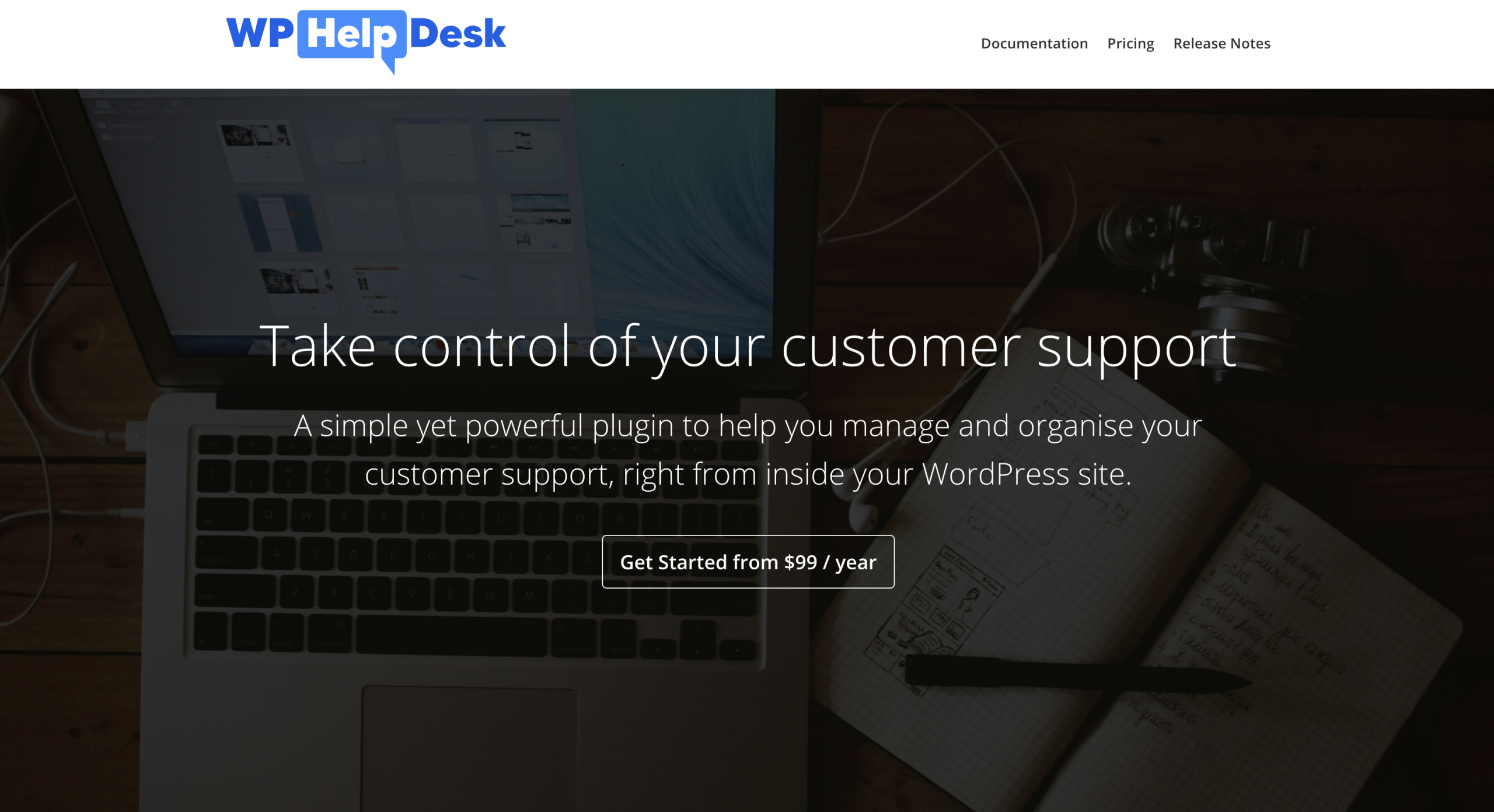 A website landing page for WP Help Desk, advertising a WordPress customer support plugin with a call-to-action button and a background image of a laptop and notebook.