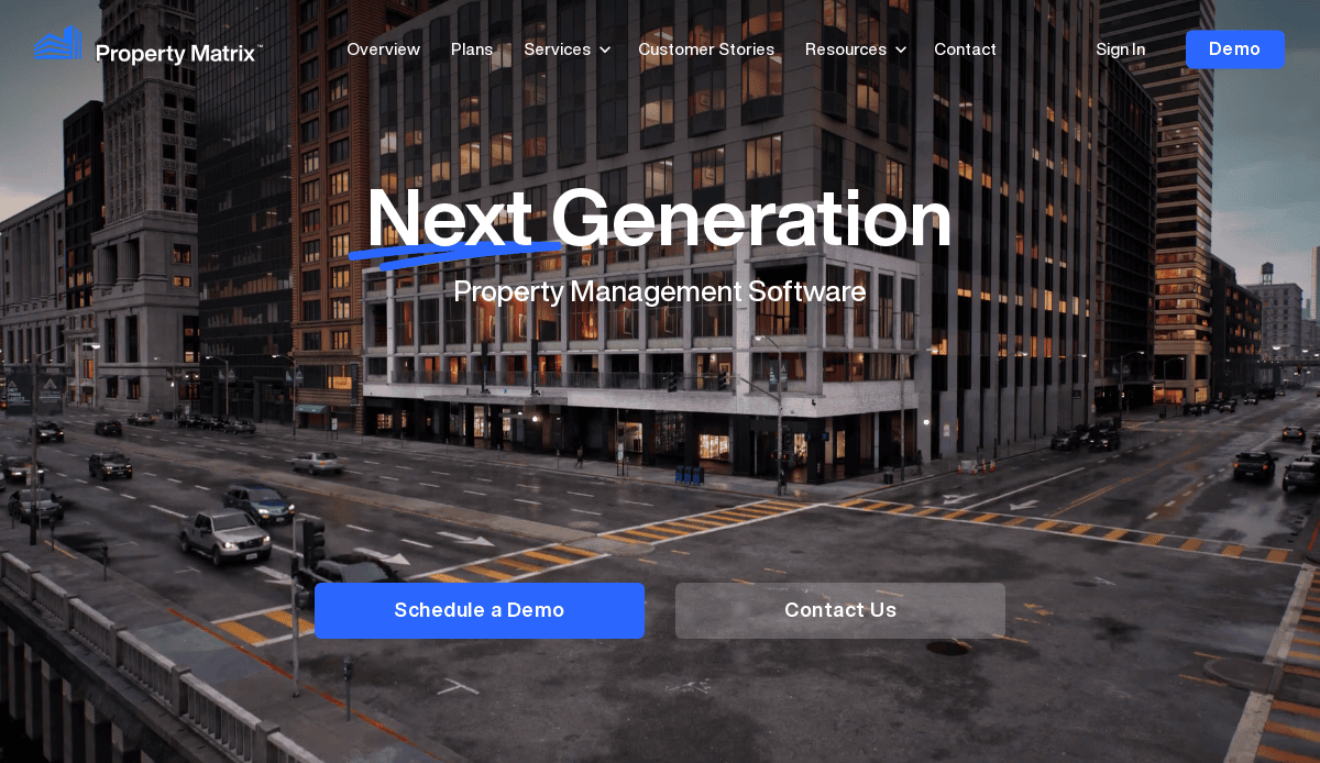 A city street corner at dusk with tall office buildings. Overlaid text reads, “Next Generation Property Management Software.” Buttons below say “Schedule a Demo” and “Contact Us.” Streamlined property management website design tops the navigation menu.