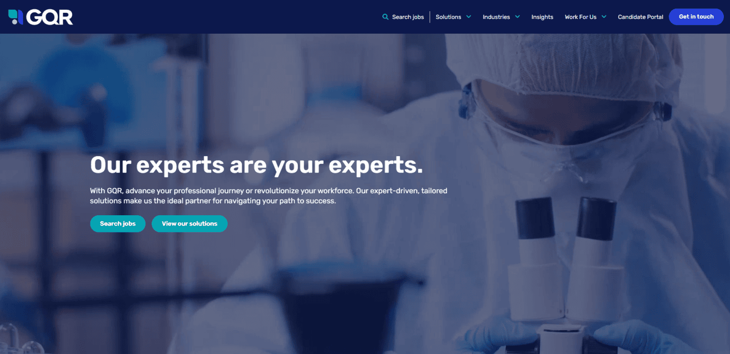 A scientist wearing protective gear looks into a microscope. White text over the image reads, “Our experts are your experts.” GQR’s recruitment agency website features navigation at the top, with buttons to search jobs and view solutions.
