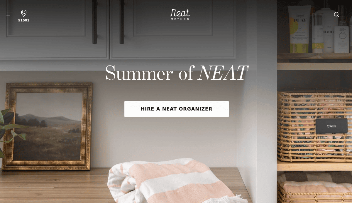 A tidy shelf with a folded striped towel, a framed landscape painting, woven baskets, and neatly arranged toiletries, overlaid with the text “Summer of NEAT” and a button labeled “HIRE A NEAT ORGANIZER—keep it running smoothly.”.