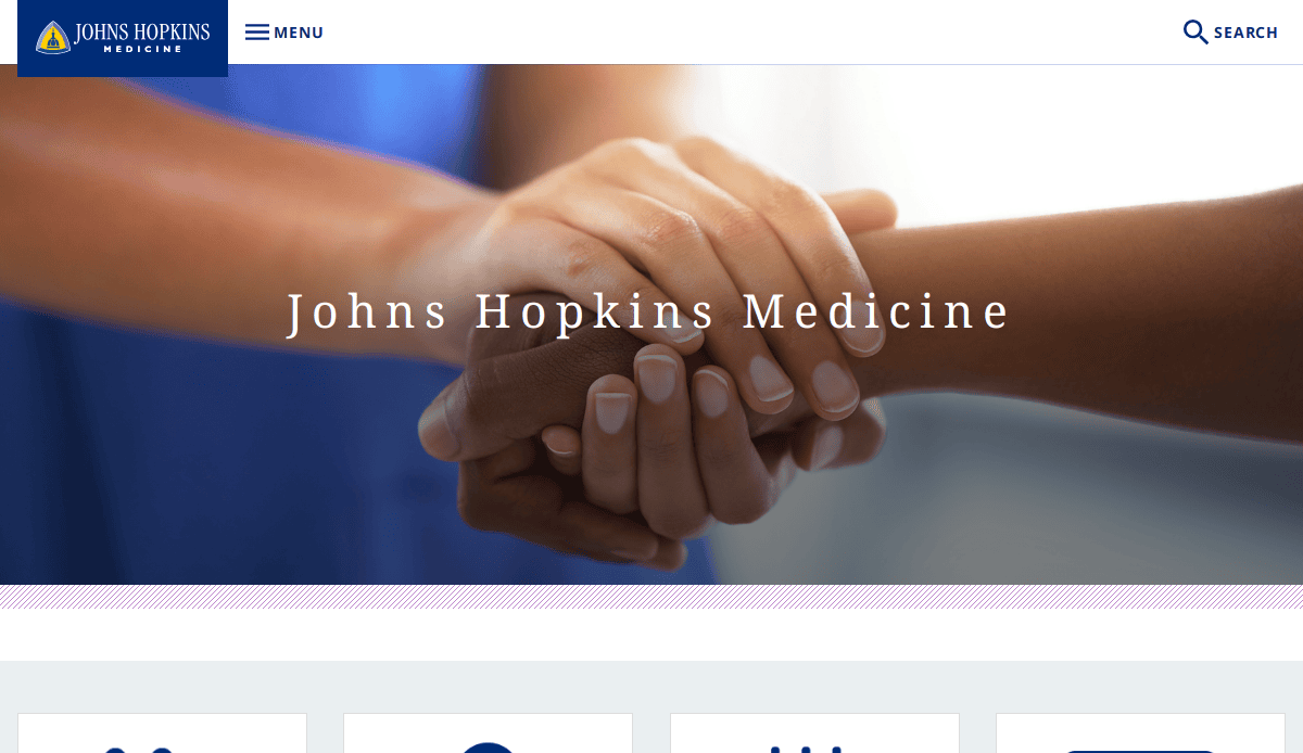 Close-up of one person gently holding anothers hand, with Johns Hopkins Medicine text overlaid; a blue menu bar with logo and search icon appears at the top, highlighting patient trust in healthcare website design.