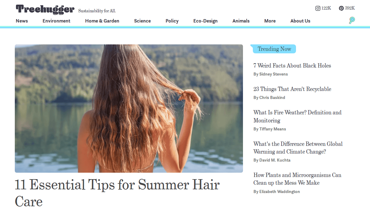 A woman with long, wavy hair stands at the edge of a lake, facing away from the camera, touching her hair. The image headlines an article on 11 Essential Tips for Summer Hair Care on this leading environmental web design website.