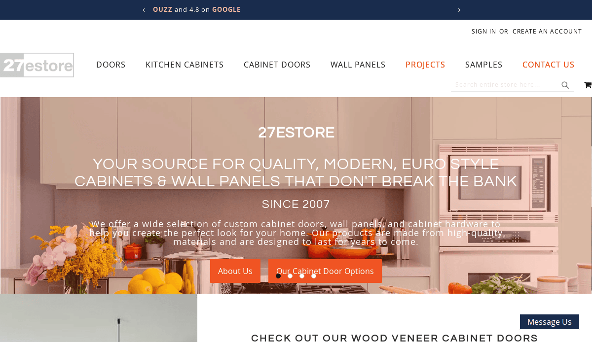 Screenshot of the 27estore website homepage, featuring a modern kitchen with cabinets, a navigation menu, and highlighted buttons for About Us and Our Cabinet Door Options over a text banner—a perfect addition to any kitchen portfolio.
