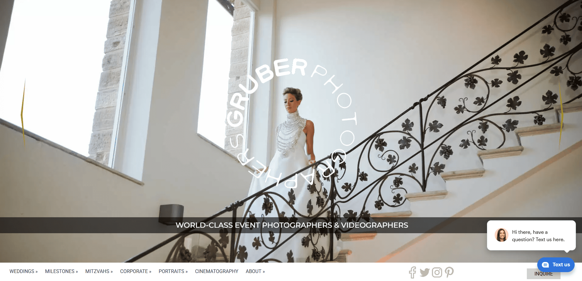 A woman in a white gown stands on an ornate staircase with a floral railing, under large windows. Text reads WORLD-CLASS EVENT PHOTOGRAPHERS & VIDEOGRAPHERS—your ultimate wedding website guide. Website navigation and chat box are visible.