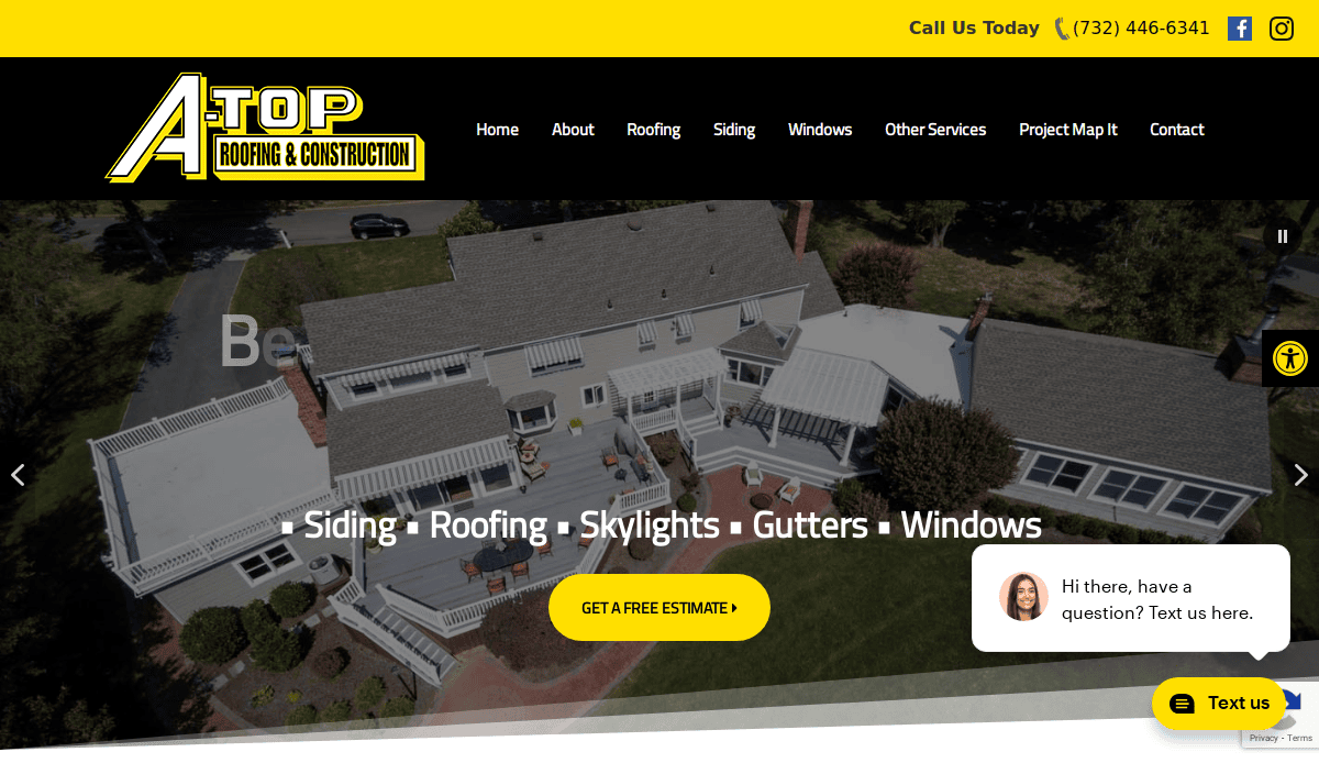 Aerial view of a large house with gray roof and white exterior, featuring multiple decks and surrounded by landscaping. The Atop Roofing & Construction website header and navigation bar are visible at the top.