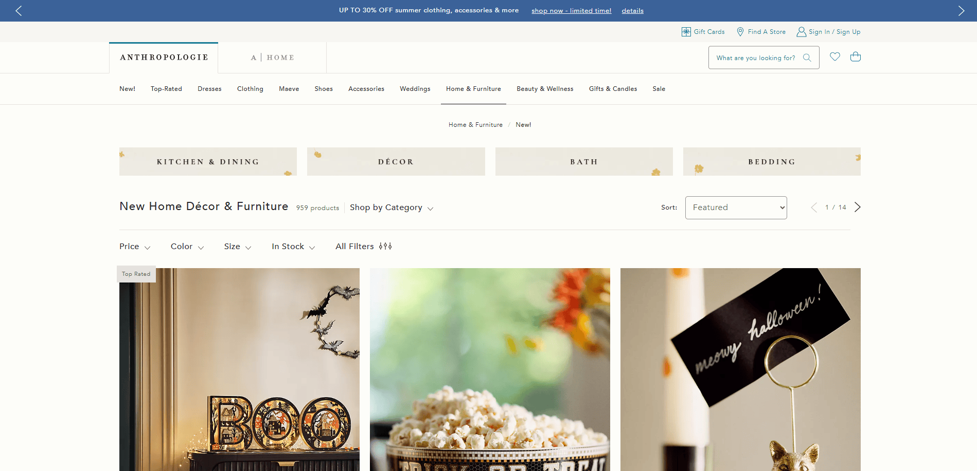 Screenshot of Anthropologie’s “New Home Décor & Furniture” page showing festive Halloween-themed decorations, including a “BOO” sign, a bowl of popcorn, and a “merry halloween!” sign. Website menu and filters are visible.