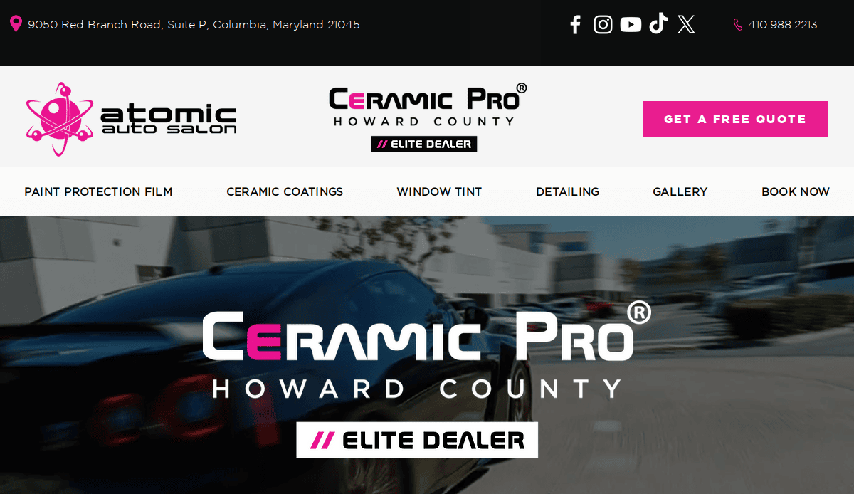 Website header for Atomic Auto Salon and Ceramic Pro Howard County, showing contact info, social media icons, and navigation links above an image of a black sports car. Elite Dealer badge and Get a Free Quote button are visible.