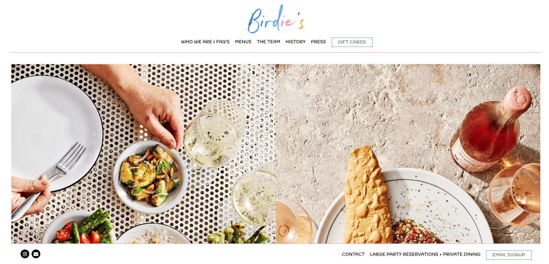 Two people dine together with plates of salad, bread, and other dishes on a white patterned table, accompanied by glasses of white wine and a bottle of rosé wine.