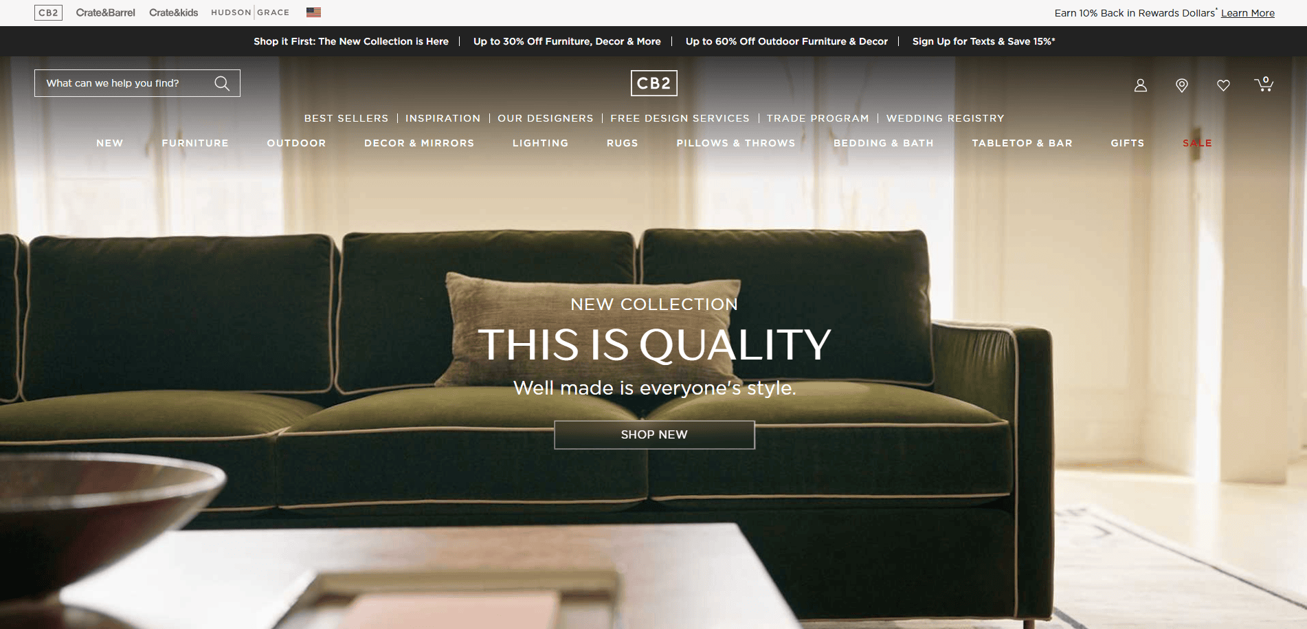 The homepage of the CB2 website features a modern green velvet sofa with a dark cushion, stylish decor, and sunlight streaming in. The screen displays the text: “NEW COLLECTION. THIS IS QUALITY. Well made is everyone’s style.”.