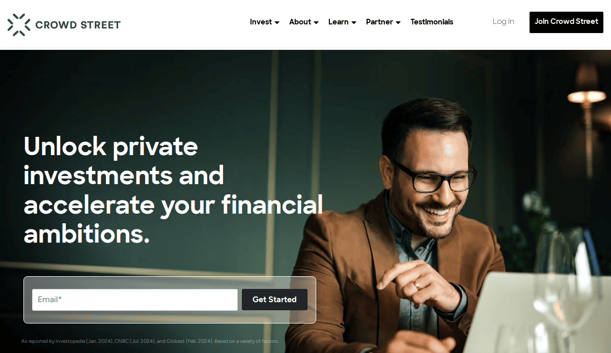 A man wearing glasses and a brown blazer smiles while using a laptop. Next to him, text reads, Unlock private investments and accelerate your financial ambitions, with an email sign-up box and a Get Started button below.