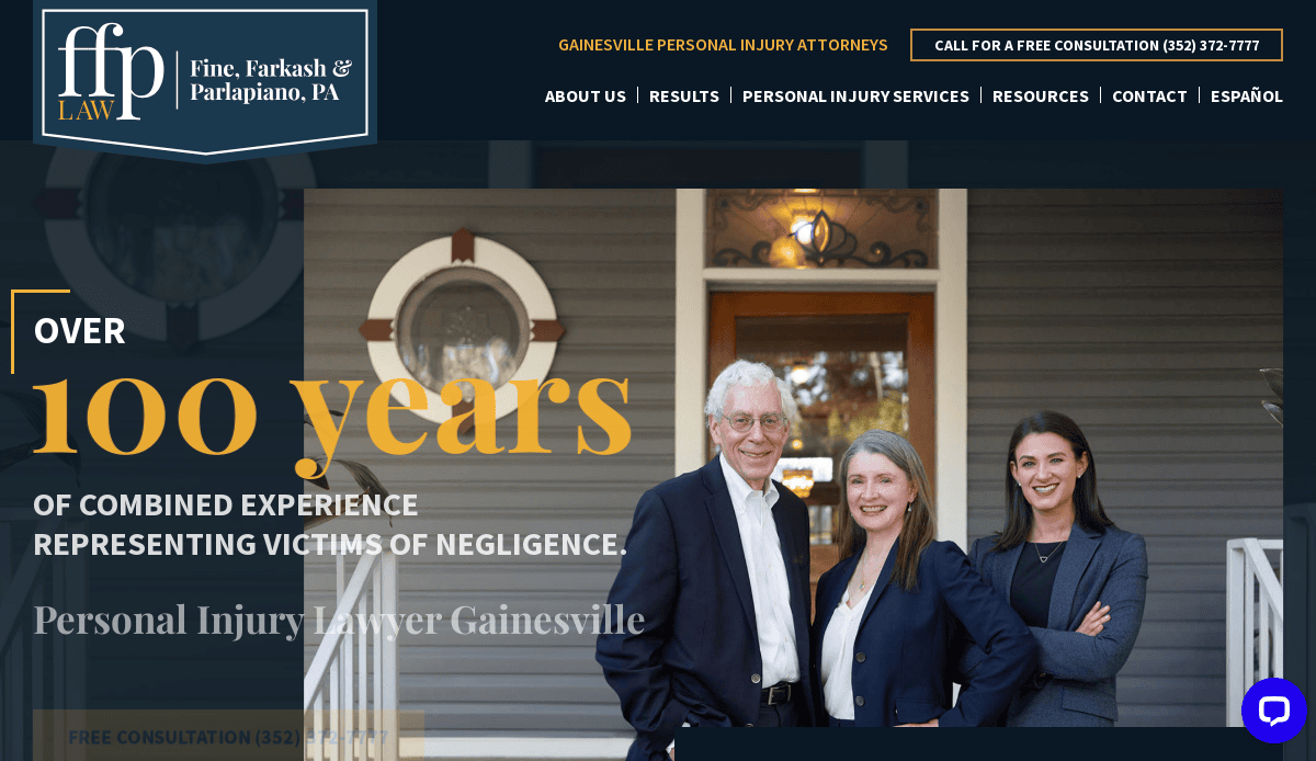 Three attorneys, two women and one man, stand smiling on a porch in front of a gray house with a white door. Text promotes over 100 years of combined personal injury law experience in Gainesville.